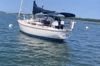Slide: The Image of 1987 Catalina 30 MK II sailboat anchored on calm water under clear blue sky. - 2