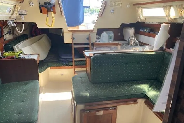 Slide: The Image of Interior of a 1987 Catalina 30 MK II sailboat with green upholstered seating. - 3