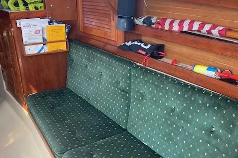 Slide: The Image of Interior of 1987 Catalina 30 MK II sailboat with green cushioned seating and wooden storage. - 6