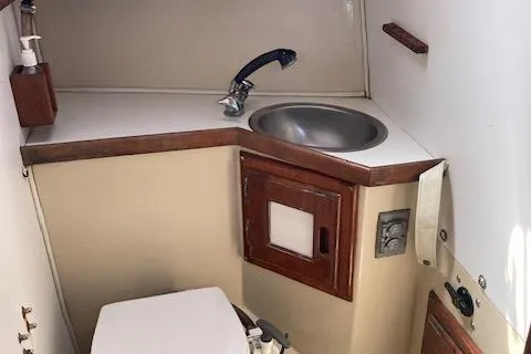 Slide: The Image of 1987 Catalina 30 MK II boat bathroom with sink, toilet, and wooden cabinetry. - 8