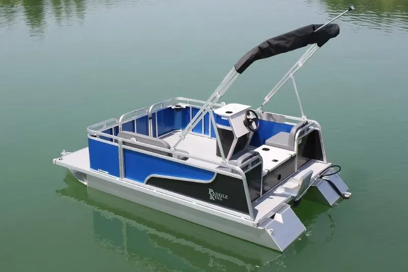 Slide: The Image of 2026 Paddle King Lo Pro Angler boat with canopy, parked on grass near industrial building. - 5