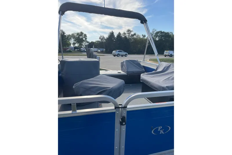 Slide: The Image of 2026 Paddle King Lo Pro Angler boat with covered seats, blue exterior, and aluminum railing. - 7
