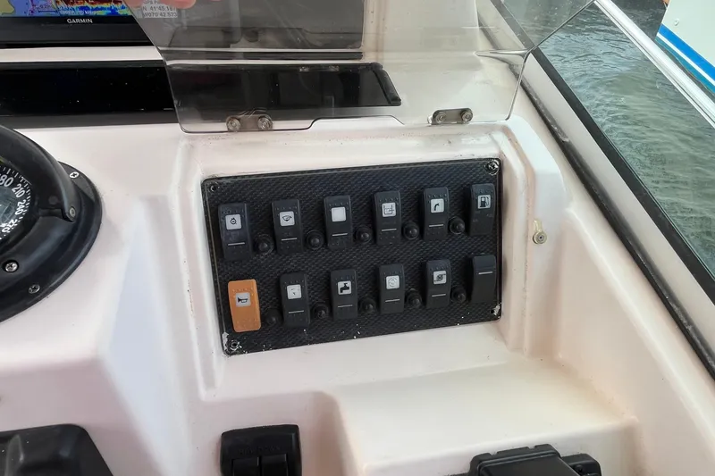 Slide: The Image of Control panel of a 2004 Grady-White Gulfstream 232 boat with various switches. - 10