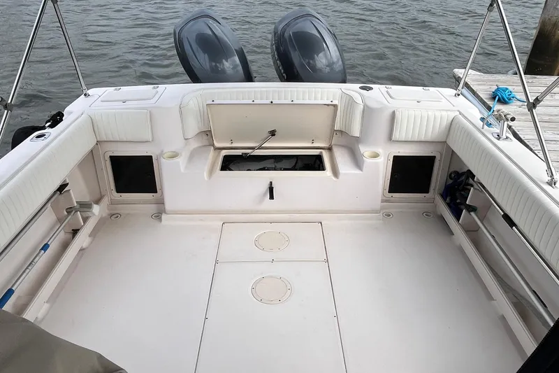 Slide: The Image of 2004 Grady-White Gulfstream 232 boat deck with twin engines and storage compartments. - 19