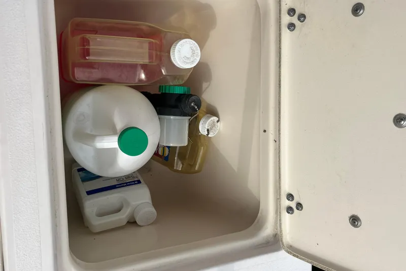 Slide: The Image of Storage compartment on a 2004 Grady-White Gulfstream 232 with various cleaning supplies. - 21