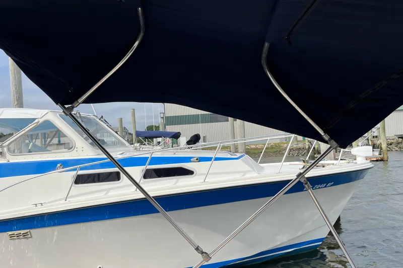 Slide: The Image of 2004 Grady-White Gulfstream 232 boat docked, partially covered by a blue canopy. - 23