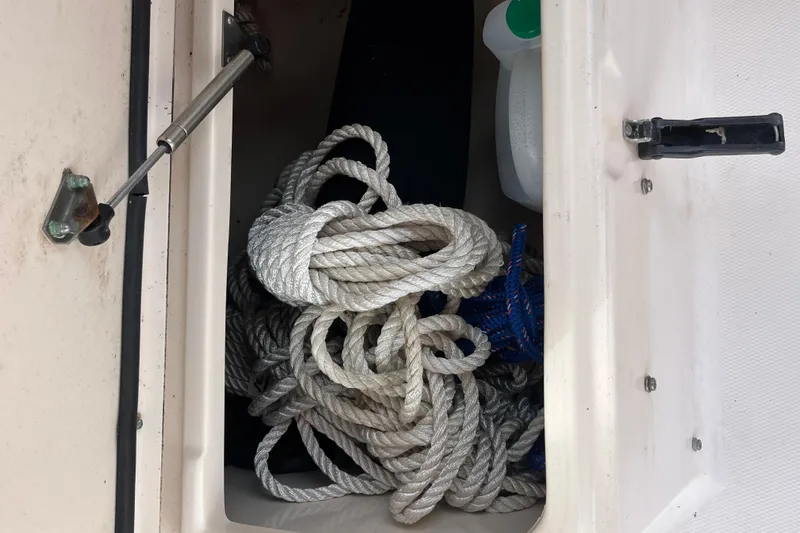 Slide: The Image of Storage compartment on a 2004 Grady-White Gulfstream 232 boat with coiled ropes. - 24