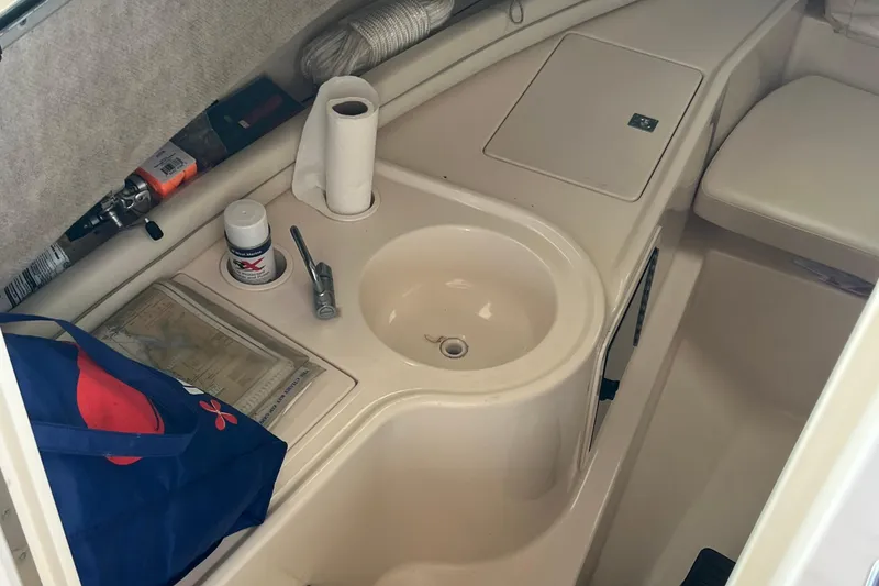 Slide: The Image of 2004 Grady-White Gulfstream 232 cabin interior with sink, storage, and accessories. - 26