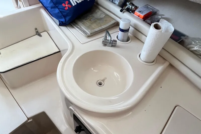 Slide: The Image of 2004 Grady-White Gulfstream 232 boat sink area with faucet and paper towel holder. - 29