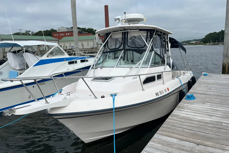 Slide: The Image of 2004 Grady-White Gulfstream 232 boat docked at a marina, overcast sky. - 3