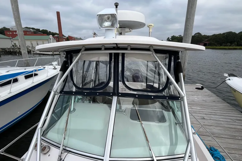 Slide: The Image of 2004 Grady-White Gulfstream 232 boat docked, featuring a covered cabin and sturdy frame. - 35