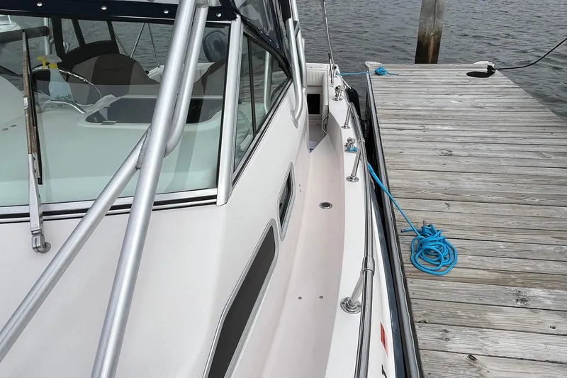 Slide: The Image of 2004 Grady-White Gulfstream 232 boat docked with blue rope on wooden pier. - 36