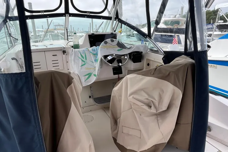 Slide: The Image of 2004 Grady-White Gulfstream 232 boat interior with covered seats and steering wheel. - 7