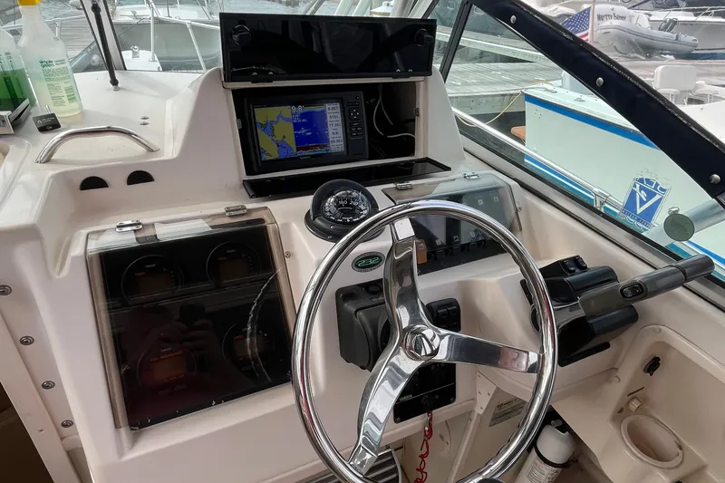 Slide: The Image of 2004 Grady-White Gulfstream 232 boat dashboard with steering wheel and navigation system. - 8
