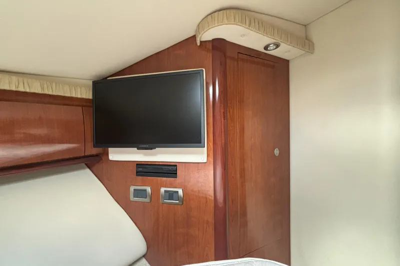 Slide: The Image of Interior of 2005 Sea Ray 420 Sundancer with mounted TV and wooden cabinetry. - 10
