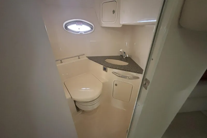 Slide: The Image of 2005 Sea Ray 420 Sundancer bathroom with sink, toilet, and porthole window. - 11