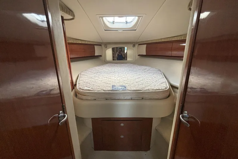 Slide: The Image of 2005 Sea Ray 420 Sundancer cabin interior with bed and wooden cabinetry. - 20