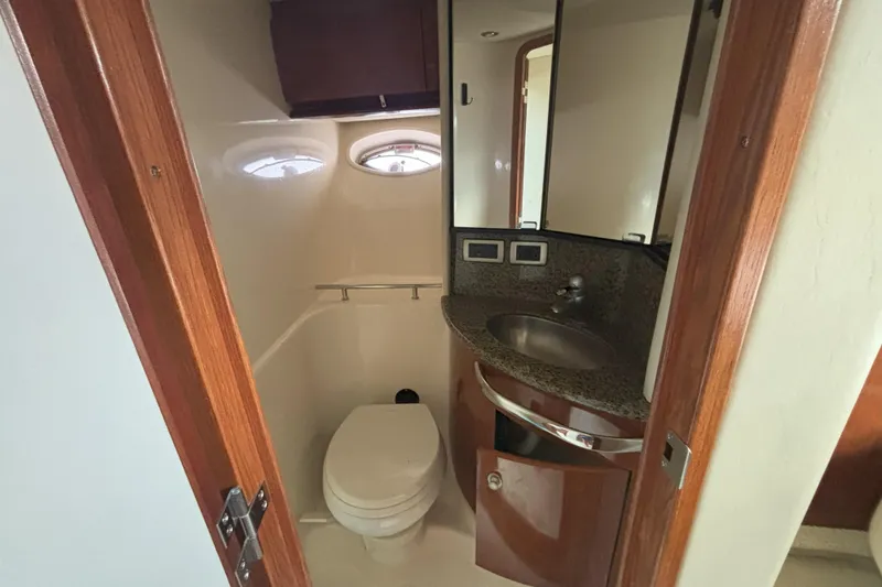 Slide: The Image of 2005 Sea Ray 420 Sundancer bathroom with sink, toilet, and mirrored cabinet. - 24