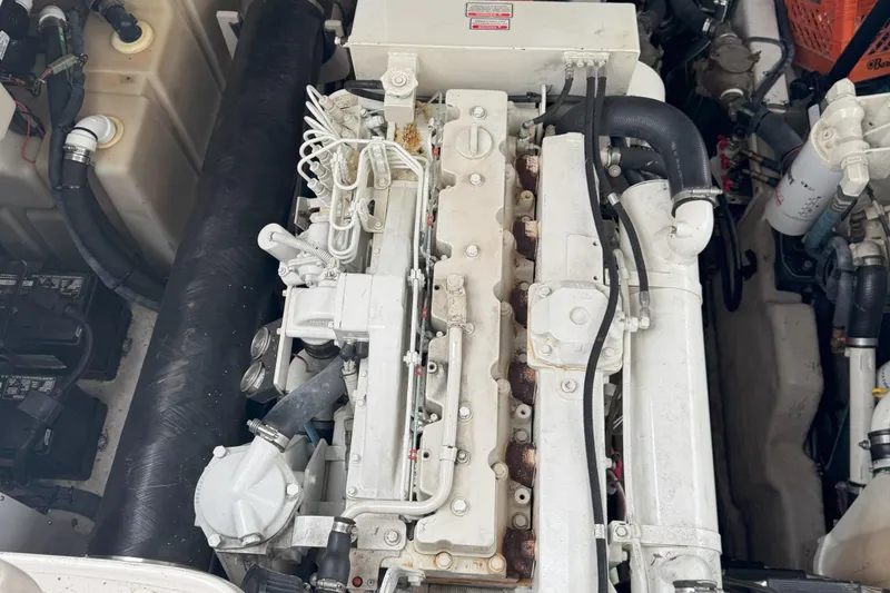 Slide: The Image of Engine compartment of a 2005 Sea Ray 420 Sundancer, showcasing mechanical components and hoses. - 26