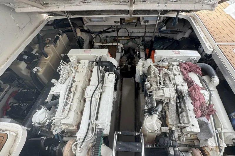 Slide: The Image of Engine compartment of a 2005 Sea Ray 420 Sundancer with dual engines and maintenance tools. - 27