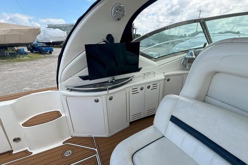 Slide: The Image of 2005 Sea Ray 420 Sundancer interior with TV, white seating, and wood flooring. - 8