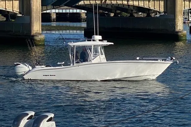 The Image of 2023 Cape Horn 32 XS boat cruising under a bridge on calm water. - 0
