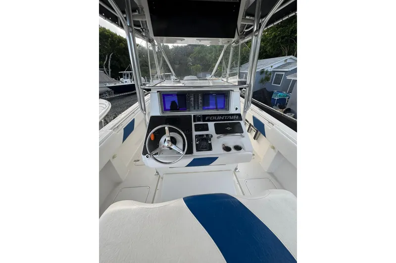 Slide: The Image of 2004 Fountain 34 CC boat cockpit with steering wheel and navigation equipment. - 11