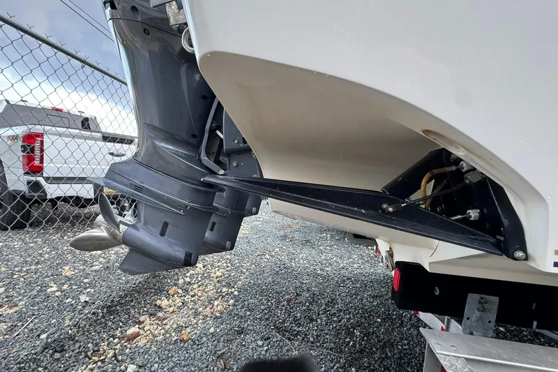 Slide: The Image of 2004 Fountain 34 CC boat engine and propeller detail near a chain-link fence. - 14