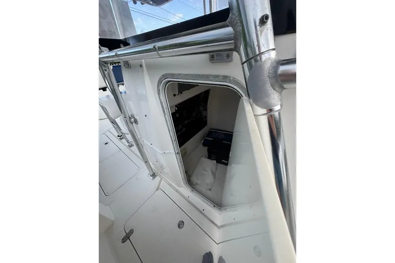 Slide: The Image of 2004 Fountain 34 CC boat interior with open storage compartment and metal railing. - 9