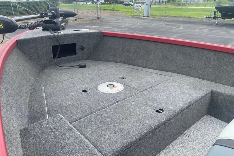 Slide: The Image of 2024 Alumacraft Escape 165 Tiller boat interior with carpeted deck and trolling motor. - 7