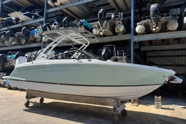 Slide: The Image of 2026 Cobalt R6 Outboard boat in storage, sleek design, under a metal canopy. - 2