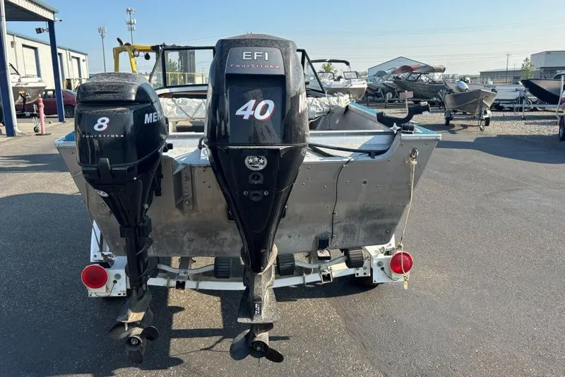 Slide: The Image of 1984 Hewescraft River Runner 16 with dual outboard motors in a boatyard. - 2