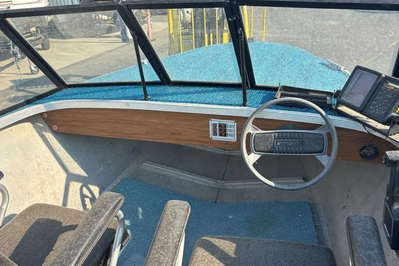 Slide: The Image of 1984 Hewescraft River Runner 16 boat interior with steering wheel and blue carpet. - 5