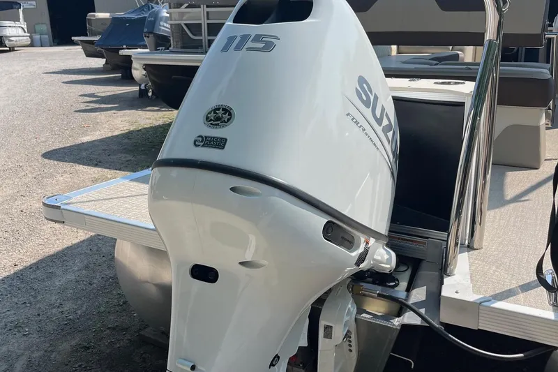 Slide: The Image of 2026 Avalon 23 LSZ Cruise Rear Bench with Suzuki outboard motor, parked outdoors. - 9