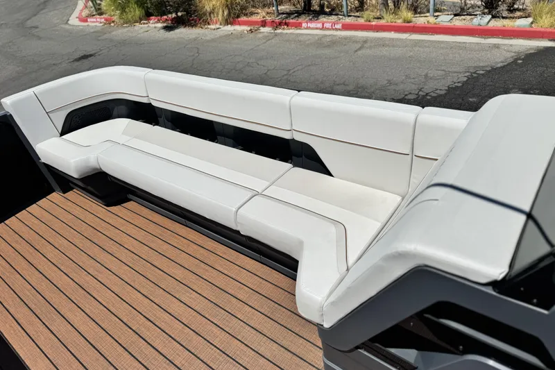 Slide: The Image of Luxurious seating on 2025 Manitou EXPLORE 26 boat with sleek white upholstery and wooden deck. - 11