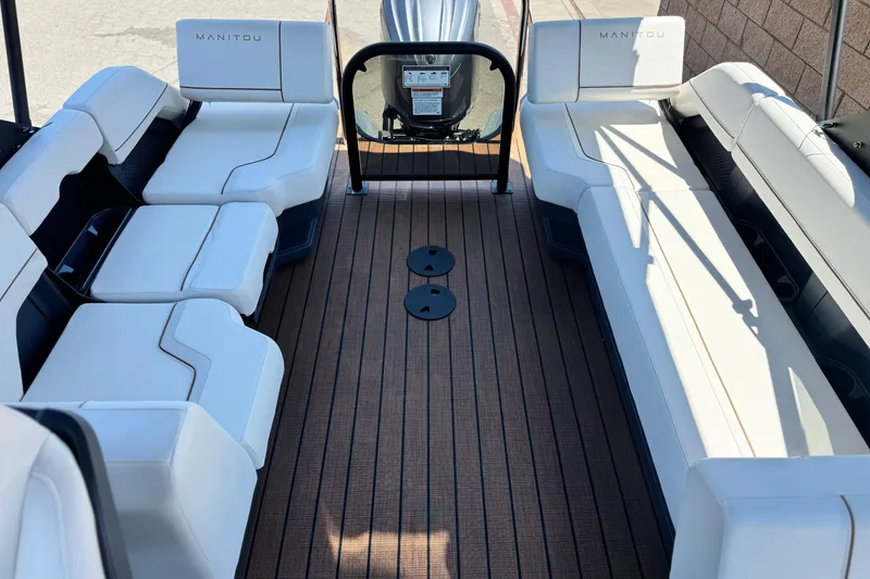 Slide: The Image of Interior of 2025 Manitou EXPLORE 26 boat with white seating and wooden flooring. - 14