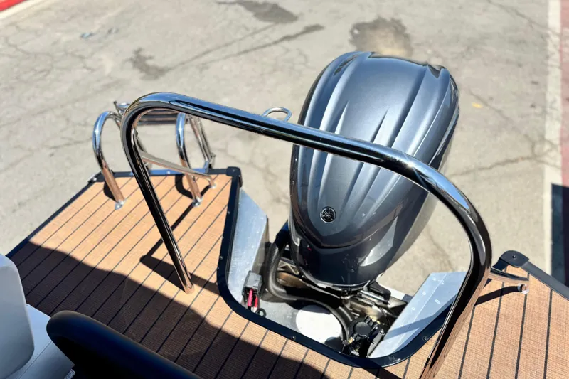 Slide: The Image of Rear view of 2025 Manitou EXPLORE 26 boat with outboard motor and deck railing. - 19