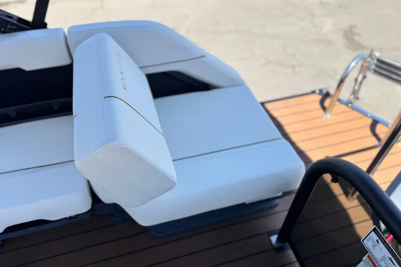 Slide: The Image of 2025 Manitou EXPLORE 26 boat interior with white seating and wooden deck. - 21