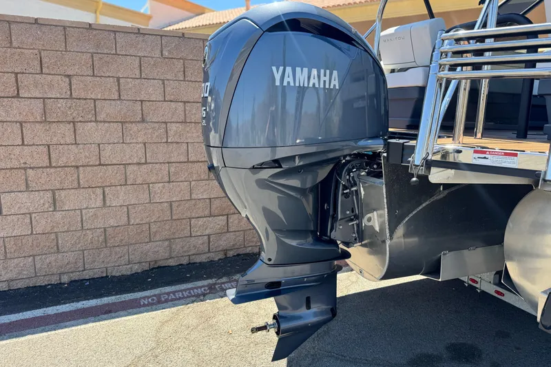 Slide: The Image of 2025 Manitou EXPLORE 26 with Yamaha outboard motor, parked by a brick wall. - 7