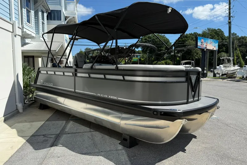 Slide: The Image of 2026 Viaggio Lago X-C pontoon boat with canopy, parked outdoors on a sunny day. - 2