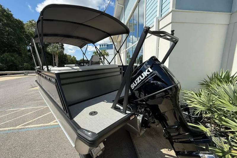 Slide: The Image of 2026 Viaggio Lago X-C boat with Suzuki outboard motor, parked near a building. - 3