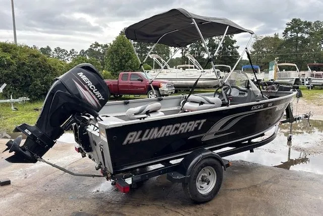 Slide: The Image of 2014 Alumacraft Escape 165 CS boat with Mercury outboard motor on trailer. - 0
