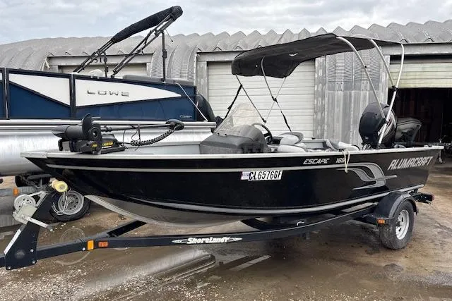 Slide: The Image of 2014 Alumacraft Escape 165 CS boat on trailer, parked outdoors. - 1