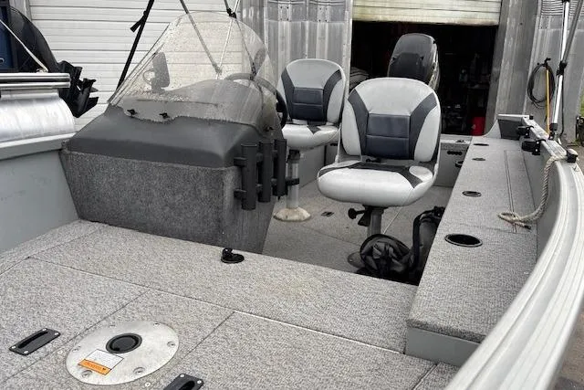 Slide: The Image of 2014 Alumacraft Escape 165 CS boat interior with seating and fishing rod holders. - 10