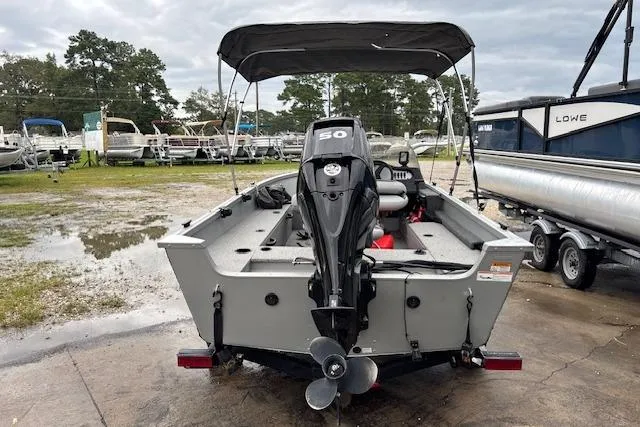 Slide: The Image of 2014 Alumacraft Escape 165 CS boat with outboard motor, parked outdoors. - 4