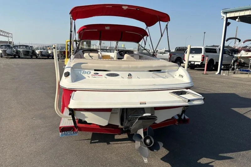 Slide: The Image of 2008 Chaparral 180 SSi boat with red canopy, parked in a marina lot. - 2