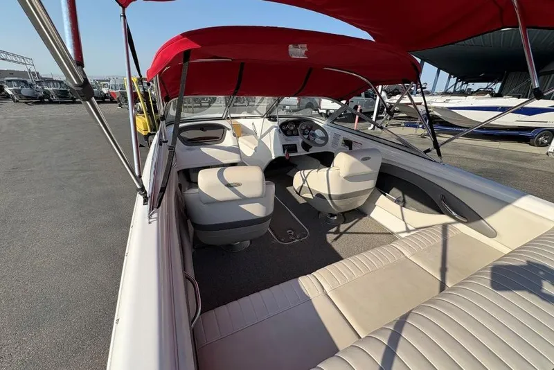 Slide: The Image of 2008 Chaparral 180 SSi boat interior with red canopy and beige seating. - 3