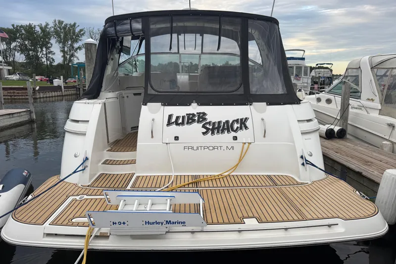 Slide: The Image of 2000 Cruisers Yachts 3870 Express docked, featuring teak decking and custom name "Lubb Shack." - 10
