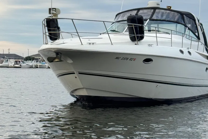 Slide: The Image of 2000 Cruisers Yachts 3870 Express boat docked on calm water. - 18