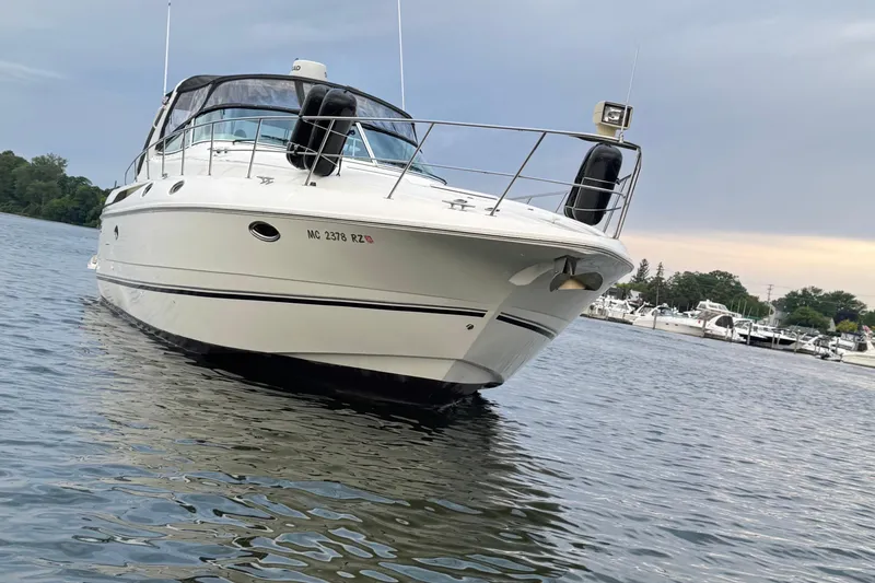 Slide: The Image of 2000 Cruisers Yachts 3870 Express on calm water near marina. - 19